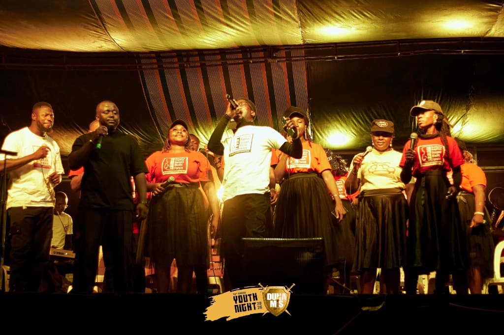 Gospel music group performing at Youth Night under warm stage lights